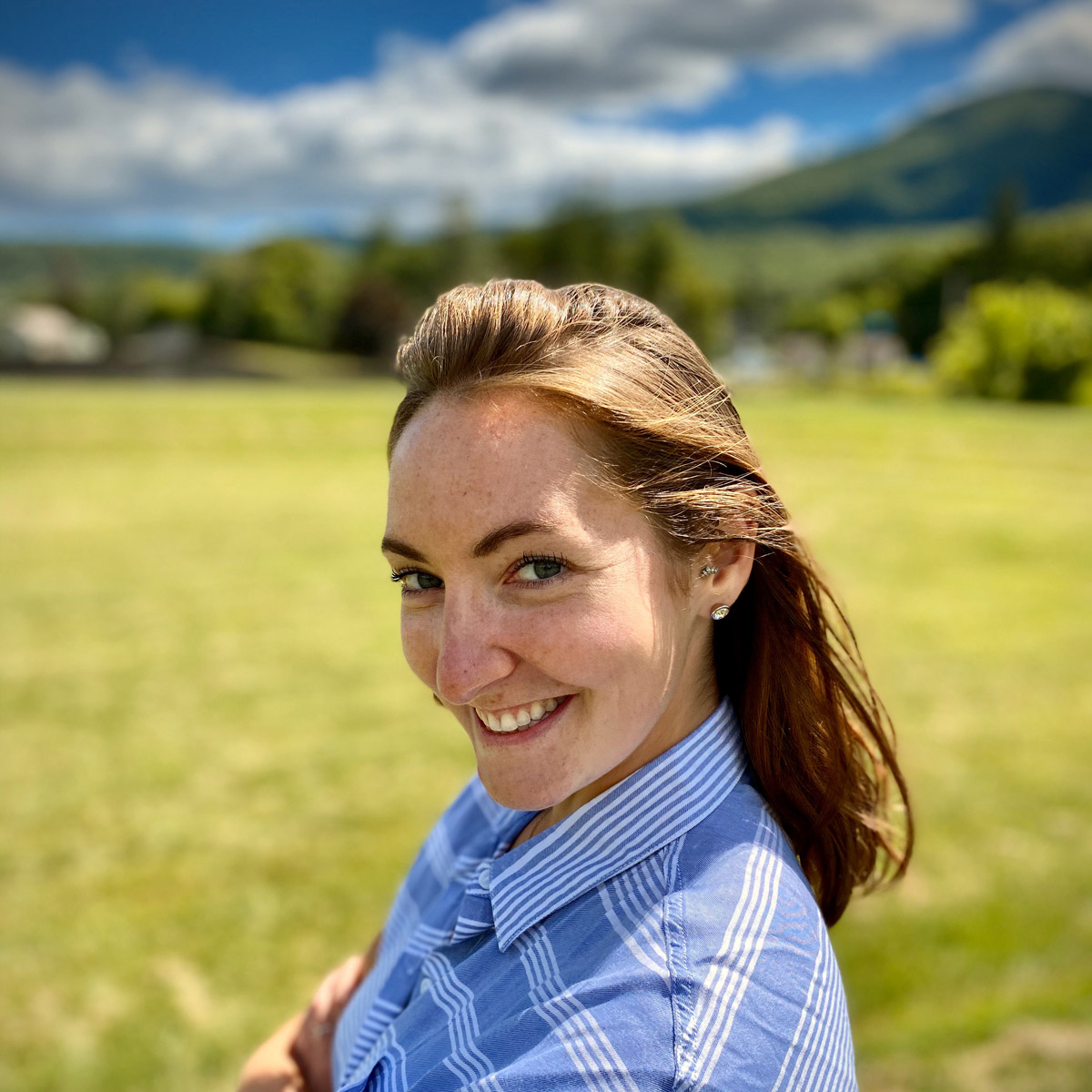 Professional portrait of Makayla McGeeney, smiling, with long hair, wearing a dark-colored top.