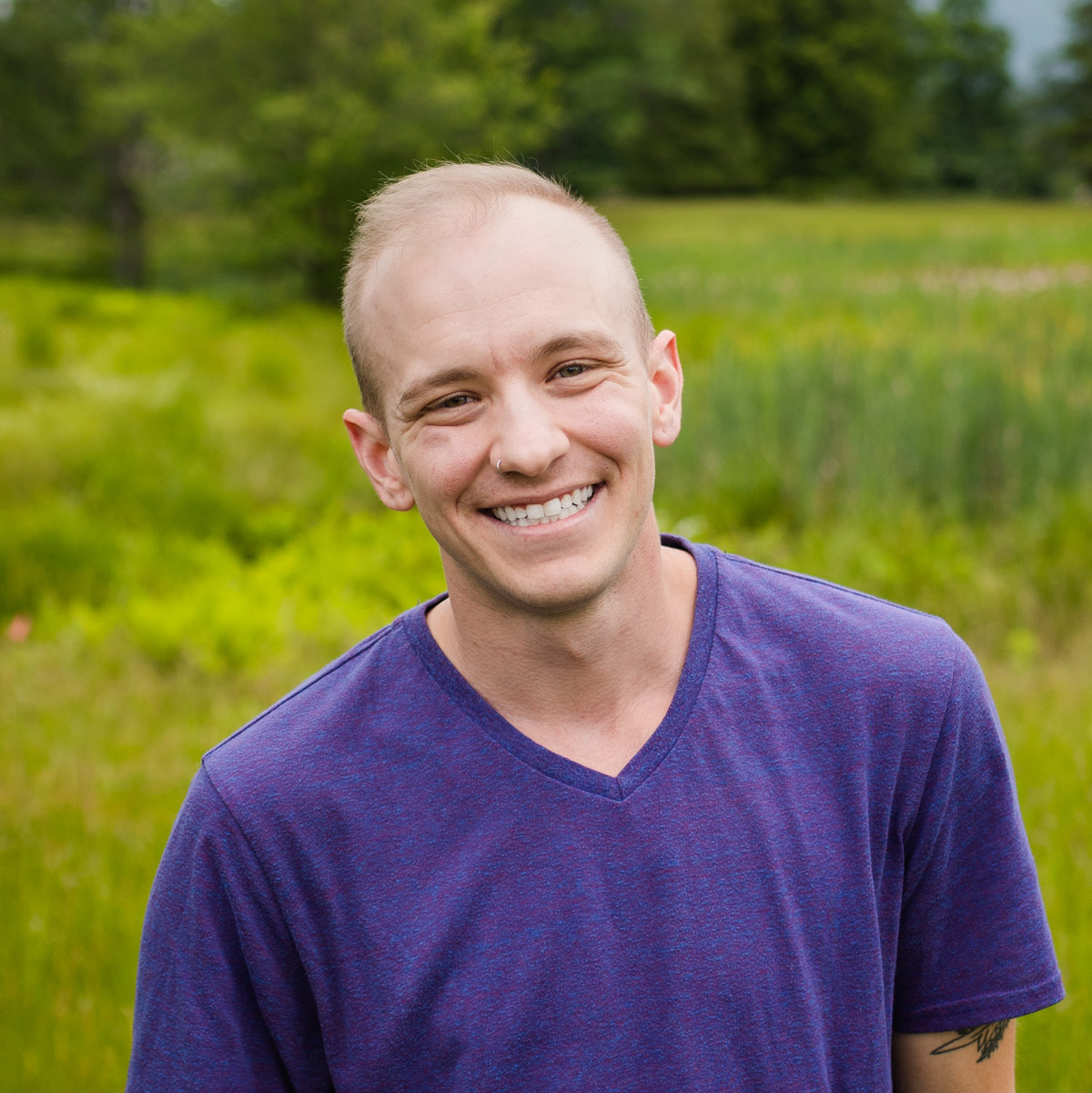 Professional headshot of Landon Marchant, smiling, with short hair, wearing a blazer and shirt.