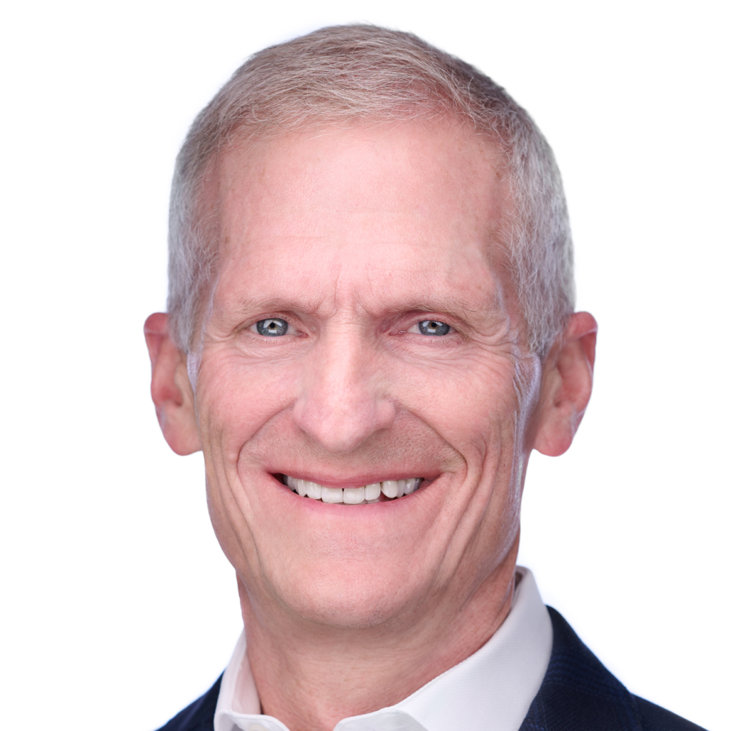 Professional headshot of Jeff Stein, smiling, with short gray hair, wearing a dark suit jacket and a white shirt, against a blurred background.
